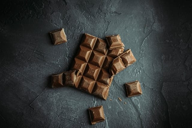 Chocolate placed over a table with its pieces broken