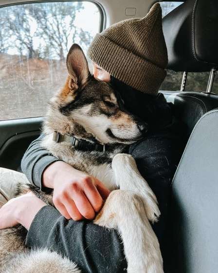 The owner holding the dog in her arms.